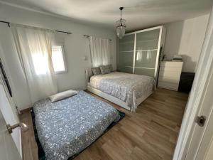 um quarto com 2 camas e um espelho em ATICO AMPLIO Y LUMINOSO em Sevilha