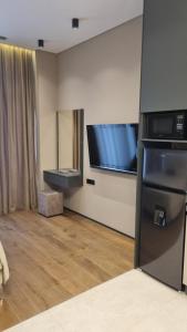 a living room with a refrigerator and a flat screen tv at Sea Breeze Lighthouse 3 in Baku