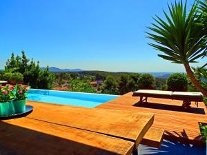 a wooden deck with a bench next to a swimming pool at Holiday Home Alexander Plana in Pallejá