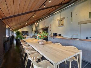 a large kitchen with a long wooden table and chairs at De neering hoeve vakantiewoning in Wielsbeke
