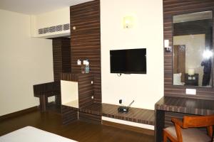 a living room with a television and a table at HOTEL KRRISH in Patna