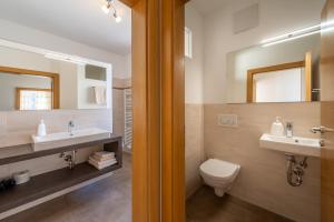 y baño con 2 lavabos, aseo y espejo. en Ferienhof Franzelin, en Termeno