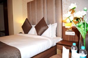 a hotel room with a bed and a vase of flowers at HOTEL KRRISH in Patna +22 photos