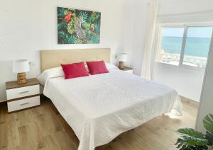 1 dormitorio con 1 cama con 2 almohadas rojas en Casa ADA, el balcón del mar, en Villaricos