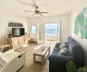 Sala de estar con sofá azul y vistas al océano en Casa ADA, el balcón del mar, en Villaricos