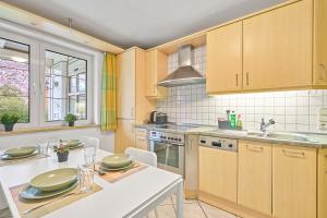 una cucina con mobili in legno e tavolo bianco di home2stay Monteur Apartmenthaus Deggendorf Wifi Smart TV Parking a Deggendorf