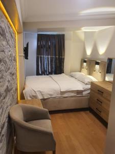 ein kleines Schlafzimmer mit einem Bett und einem Stuhl in der Unterkunft KADIKÖY BRISTOL HOTEL in Istanbul