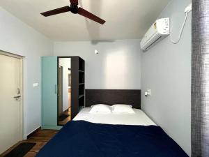 1 dormitorio con 1 cama y ventilador de techo en Soundarya Sapphires en Bangalore