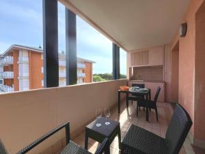 a balcony with a table and chairs and a kitchen at Capitol Apartments in Grado