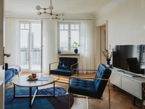 sala de estar con 2 sillas azules y mesa en Ferienwohnung Bodenseeblick, en Allensbach