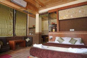 - une chambre d'hôtel avec un lit et une chaise et une publicité dans l'établissement Hotel Gandhi's Paradise, à Dharamshala