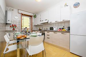 een keuken met witte apparatuur en een tafel en stoelen bij Appartamento Verona For You - Happy Rentals in Verona