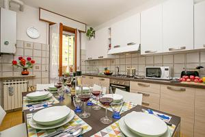 een keuken met een tafel met borden en wijnglazen bij Appartamento Verona For You - Happy Rentals in Verona
