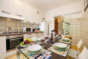 een keuken met een tafel met borden en wijnglazen bij Appartamento Verona For You - Happy Rentals in Verona