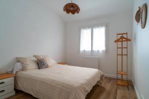 a white bedroom with a bed and a window at Villa Ti Vakansou - Avec piscine privée in Clohars-Carnoët +16 photos