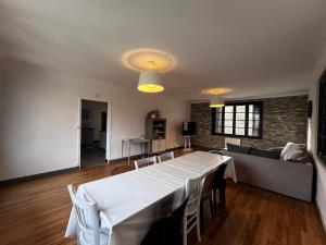 uma sala de estar com uma mesa branca e um sofá em Grand gîte 23 couchages em Lalandusse