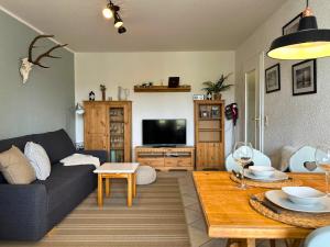 a living room with a couch and a table at SCHWARZWALDNACHT mit Sauna im Haus ideal zum wandern und biken Balkon Tiefgarage E-Ladestation in Todtnauberg