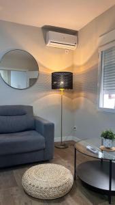 ein Wohnzimmer mit einem blauen Sofa und einem Spiegel in der Unterkunft Meta Habitat Ramon Lujan A in Madrid