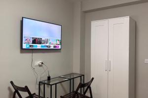 ein Wohnzimmer mit 2 Stühlen und einem TV an der Wand in der Unterkunft Meta Habitat Ramon Lujan A in Madrid