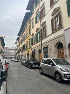 una fila di auto parcheggiate in una strada accanto agli edifici di CHARMING HOME LE RUOTE a Firenze