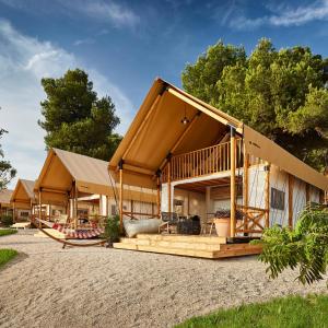 a house with a wrap around porch with a deck at Arena One 99 Glamping in Pula