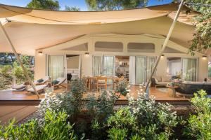 una sala de estar con una sombrilla grande en una terraza en Arena One 99 Glamping en Pula