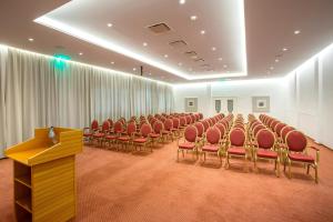 a conference room with red chairs and a podium at Cavo Maris Beach Hotel in Protaras +37 photos