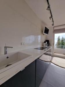 a white kitchen with a sink and a window at Vier Jahreszeiten 5-15 in Großenbrode