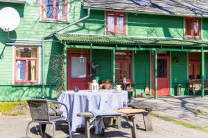 una mesa y sillas frente a una casa verde en Raibie Logi en Ventspils