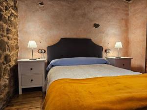 a bedroom with a bed and two night stands with lamps at 14A09 Casa de la Capilla in Colunga
