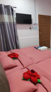 two red beds with stuffed animals on top of them at Santai Desa Chalet musleem 0nly in Brinchang