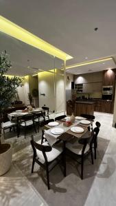 een eetkamer met een tafel en stoelen en een keuken bij M Residence - العبيكان هلز 3 in Riyad