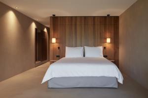 a bedroom with a large white bed and wooden walls at Saltus in San Genesio Atesino