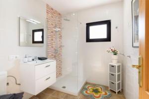 a white bathroom with a shower and a sink at Villa Primera in Playa Blanca +22 photos