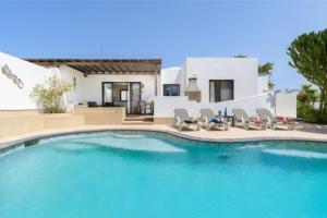 a large swimming pool in front of a house at Villa Primera in Playa Blanca
