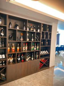 a shelf filled with lots of bottles of alcohol at Hotel Neon in Timişoara
