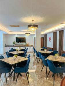 a dining room with tables and blue chairs at Hotel Neon in Timişoara +24 photos