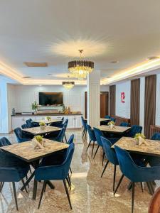 a dining room with tables and blue chairs at Hotel Neon in Timişoara
