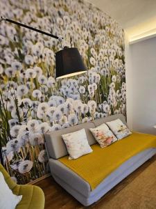 a living room with a couch and a flower mural at Yellow Flat by GrazRentals with best location & free parking in Graz