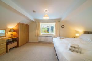 a bedroom with a large bed and a window at 2 Peggies Barn in Maulds Meaburn