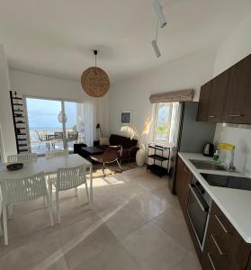 a kitchen and living room with a table and chairs at Cloudberry in Kalyves