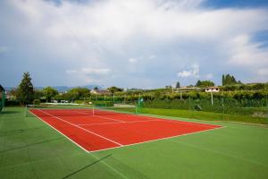 un campo da tennis con rosso e verde di Bardolino Garden Pool & Tennis on the lake - Happy Rentals a Bardolino