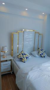 a bed with two pillows and a lamp on a table at Luxury Apartment Lavington in Mutomo
