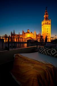 a large building with a clock tower at night at Casa Guadalupe in Seville