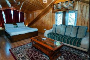 a living room with a bed and a couch at Moonlit Mansion in Shimla