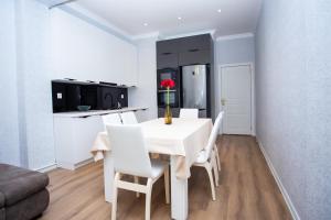 uma sala de jantar branca com uma mesa branca e cadeiras brancas em Private Family apartment em Sumqayıt