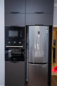 a kitchen with a refrigerator and a microwave at Private Family apartment in Sumqayıt