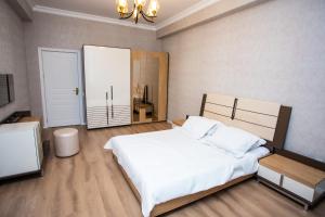 - une chambre avec un grand lit blanc et un miroir dans l'établissement Private Family apartment, à Soumgaït