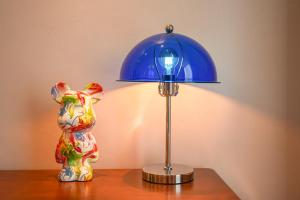 a table with a blue lamp and a statue of a dog at Wind sleeping Color Hotel - Free car to the Canton Fair-Line7 18Nancun Wanbo STN in Guangzhou