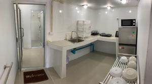 uma pequena cozinha branca com um lavatório e um frigorífico em Amazing Inn Koh Tao em Ko Tao